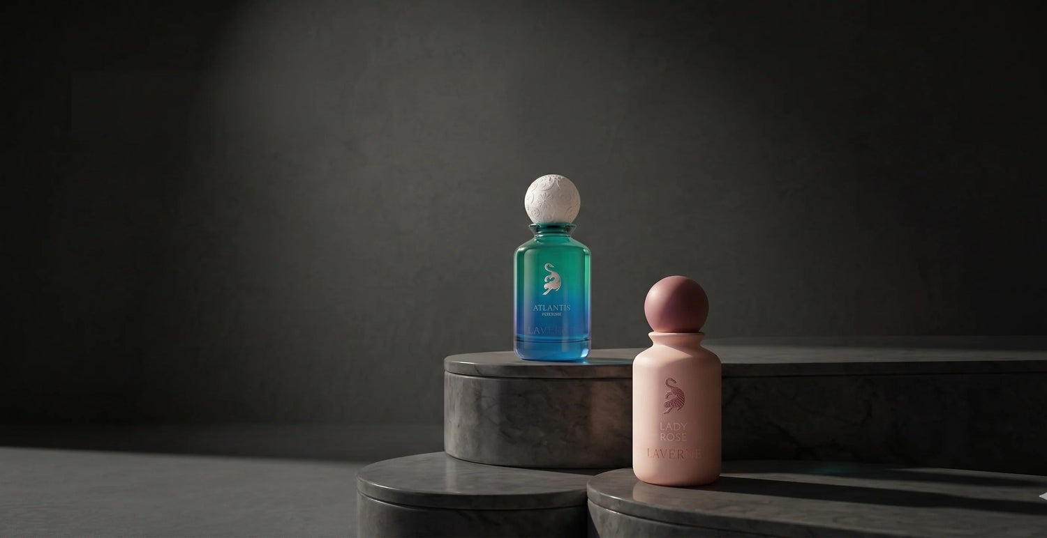 Two luxury Arabian perfume bottles, Atlantis and Lady Rose, displayed on marble pedestals.