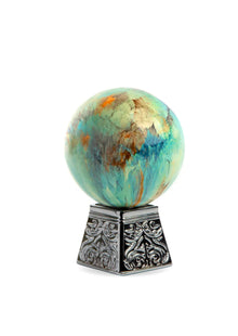 Decorative marbled oud perfume bottle with ornate silver base, luxury Arabian fragrance.