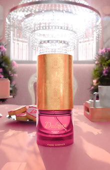 Elegant Dulzur pink and gold perfume bottle on pink table, luxury chandelier background