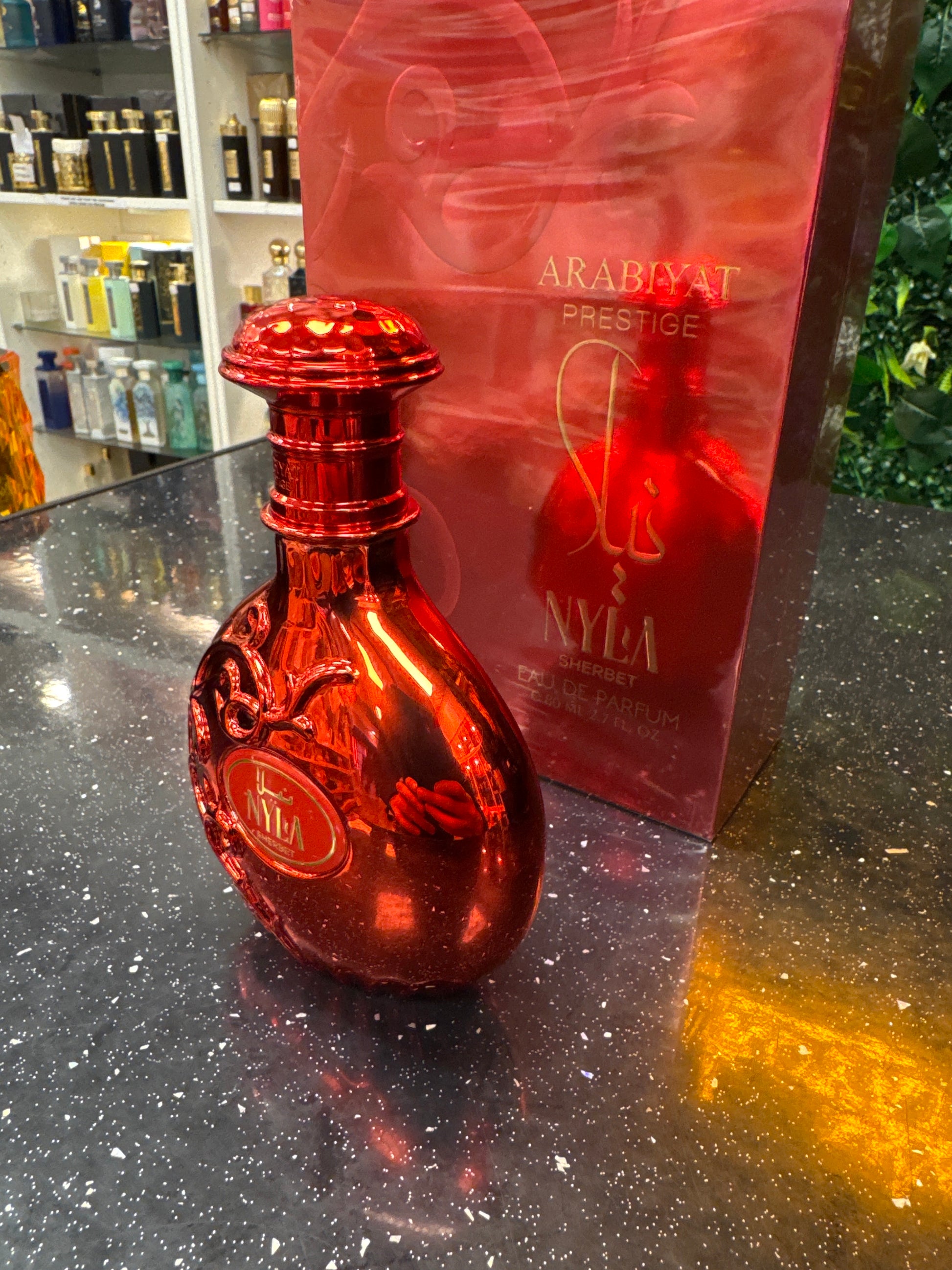 Red bottle with a visible brand logo on a reflective surface