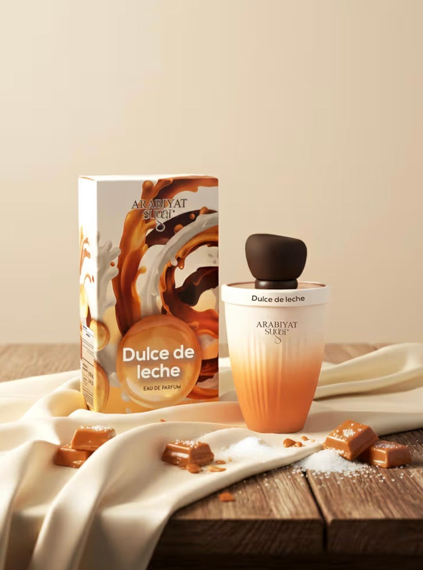 Dulce de leche perfume bottle and packaging on a wooden surface with a neutral background