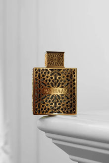 Luxurious gold Arabian oud perfume bottle with intricate geometric pattern, labeled RAYHAAN