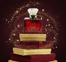 Red Arabian oud perfume bottle with crystal cap on stacked gold and burgundy gift boxes, surrounded by golden star sparkles.