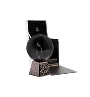 Decorative black sphere on a stand with a box in the background