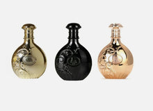 Three elegant Arabian oud perfume bottles in gold, black and rose gold with ornate detailing
