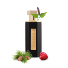 Luxury black oud perfume bottle with gold label, surrounded by pine, raspberry, and mint leaves
