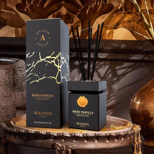 Rose Vanilla reed diffuser in black and gold packaging on ornate table, Arabian decor background