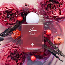 Arabic perfume bottle with white cap, surrounded by pink peonies, berries, and vanilla pods.