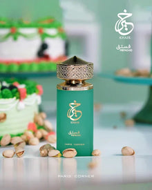 Green Khair Pistachio perfume bottle with gold cap, pistachios, and pastel cake background.