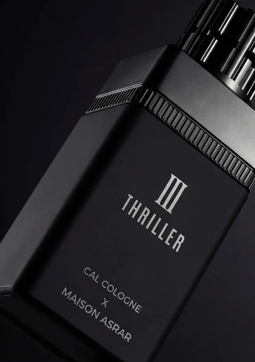 Black cologne bottle with 'Thriller' branding on a dark background