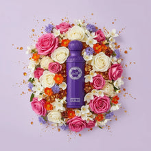 Purple Arabian oud perfume bottle surrounded by pink, white, and orange flowers on pastel background.