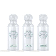 Three white Arabian oud perfume bottles labeled Oryx, Oasis, and Sahara with ornate caps.