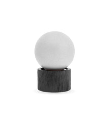 Minimalist air freshener with white spherical top on black wood base, modern home decor
