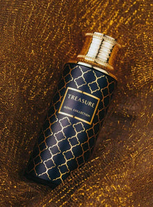Luxury Arabian oud perfume bottle with gold pattern and cap on golden textured fabric.