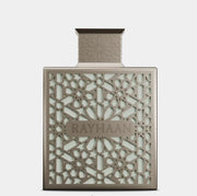 Perfume bottle with intricate design and 'RAYHAAN' branding on a light gray background