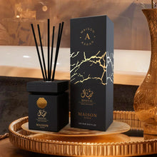 Luxury Arabian oud reed diffuser with black and gold packaging on a decorative tray.