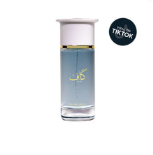 Clear glass bottle of Arabian oud eau de parfum with Arabic script and white cap on white background.