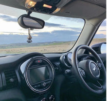 Car interior with hanging Arabian oud air freshener and countryside view through windshield
