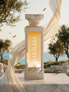 Luxury perfume bottle labeled 'Marmara' with column design, set outdoors by the sea with trees.