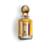 Velvet Body Oud perfume bottle with gold round cap and Arabic calligraphy on a white background