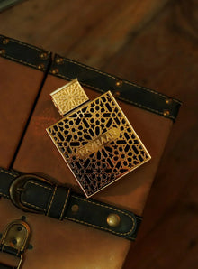 Rayhaan Arabian oud perfume in ornate gold bottle on leather trunk