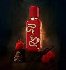 Red perfume bottle with gold snake design, surrounded by strawberry, raspberry, vanilla, and pine cone.