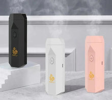 Three portable electronic bakhoor burners in black, white, and pink emitting oud fragrance.