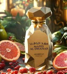 Gold geometric perfume bottle labeled MAHD AL DHAHAB surrounded by grapefruit and berries.