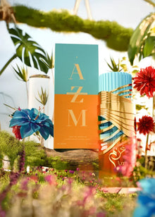 Colorful Arabian oud perfume bottle and box with gold accents, surrounded by flowers outdoors