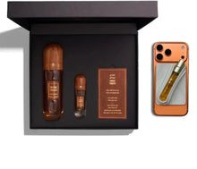Vintage Tobacco oud perfume gift set with two bottles, card, and travel spray on smartphone.