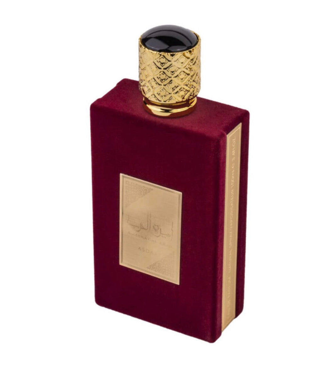 Luxury Arabian oud perfume bottle with burgundy velvet finish and ornate gold cap
