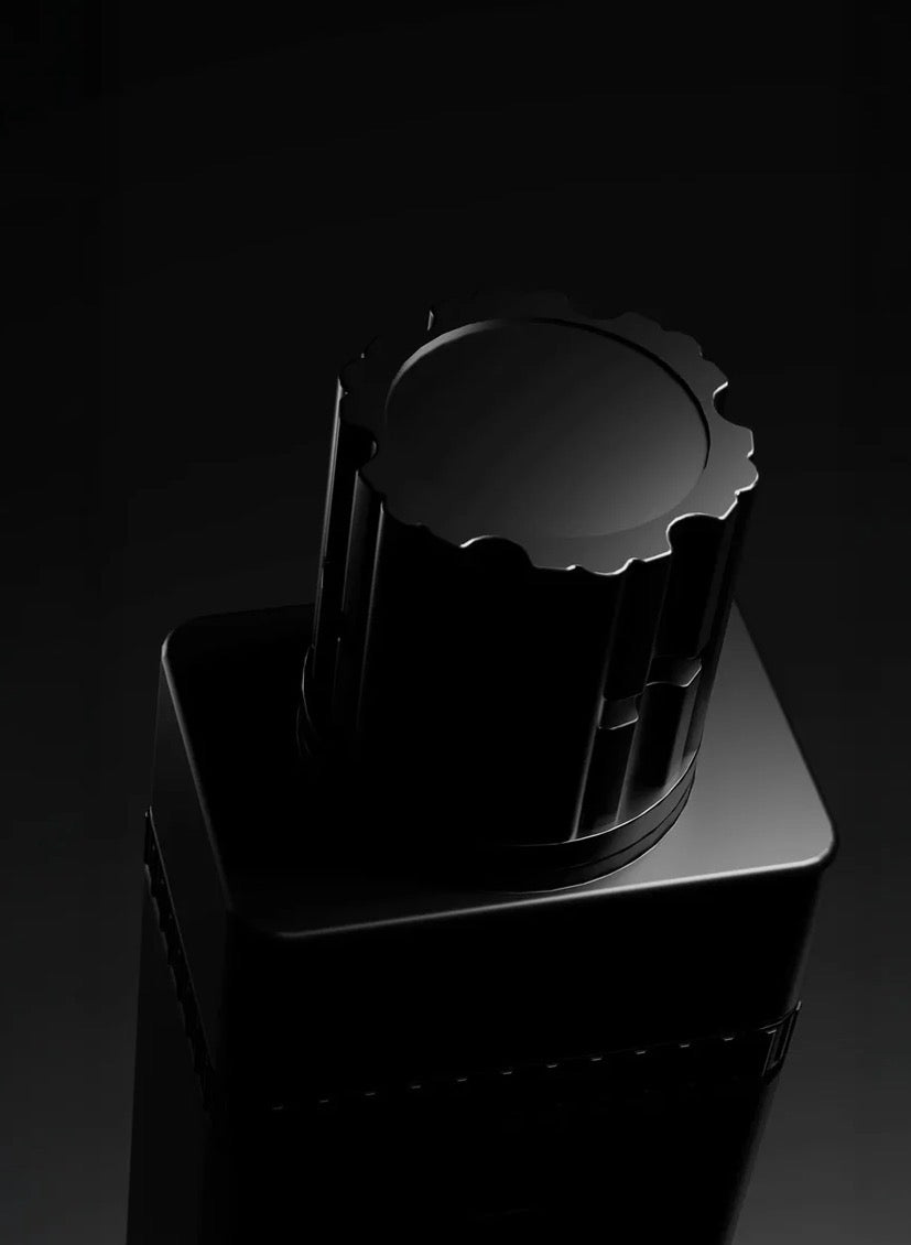 Black cylindrical object with a textured top on a dark background