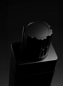 Close-up of a luxury black Arabian oud perfume bottle against a dark background