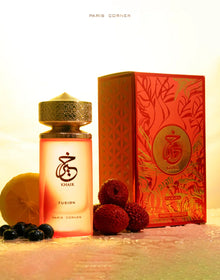 Khair Fusion perfume bottle with gold cap, red box, lychee, blueberry, and lemon slices