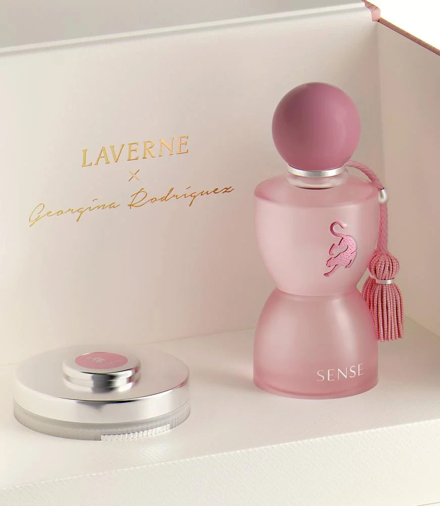 Pink perfume bottle with tassel and 'Laverne' branding on a white background