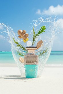 A turquoise perfume bottle on a sunny beach with ginger, sea salt, cedarwood, and splashing water.