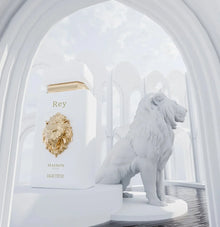 Luxury Arabian oud perfume bottle with gold lion emblem beside white lion statue in elegant archway