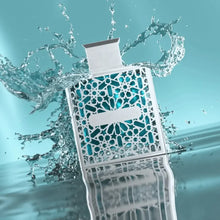 Arabian oud perfume bottle with ornate geometric pattern and water splash on turquoise background