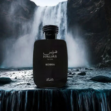 Hawas Kobra for Him black perfume bottle with Arabic text, displayed in front of a powerful waterfall.