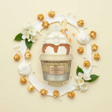 Perfume bottle shaped like whipped cream dessert, surrounded by caramel popcorn, jasmine flowers, and cream.