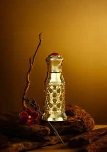 Luxury Arabian oud perfume bottle with gold detailing, orchid and lavender accents, on rocks
