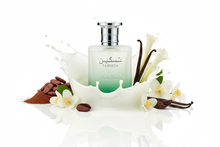 Taskeen perfume bottle with milk splash, vanilla beans, cocoa beans, and white flowers