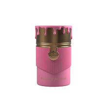Pink and gold perfume bottle with ribbed design and strawberry pound cake label, isolated on white background.