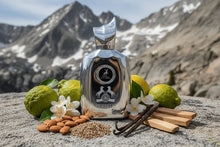 Silver Alhambra Perseus perfume bottle with bergamot, almonds, vanilla, jasmine, spices and woody notes displayed outdoors in a mountain setting.