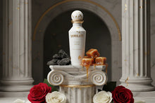 Gold Musk perfume bottle on marble pedestal with caramel, oud wood, red and white roses