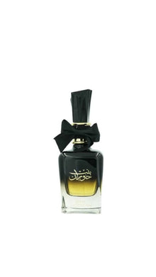 Elegant black and gold perfume bottle with Arabic script and black bow on white background