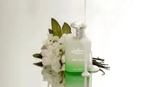 Taskeen Lactea Divina perfume bottle with white flowers, vanilla pods, and milk splash