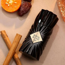 Black Royal Blend Nero perfume bottle with cinnamon sticks, orange slice, and date fruit.