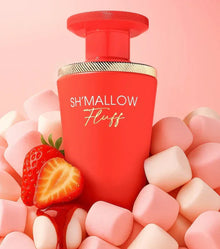 Red Sh'Mallow Fluff perfume bottle surrounded by pink marshmallows and strawberries