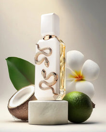 Luxury white perfume bottle with gold snake design, surrounded by coconut, lime, green leaf, and white flower.